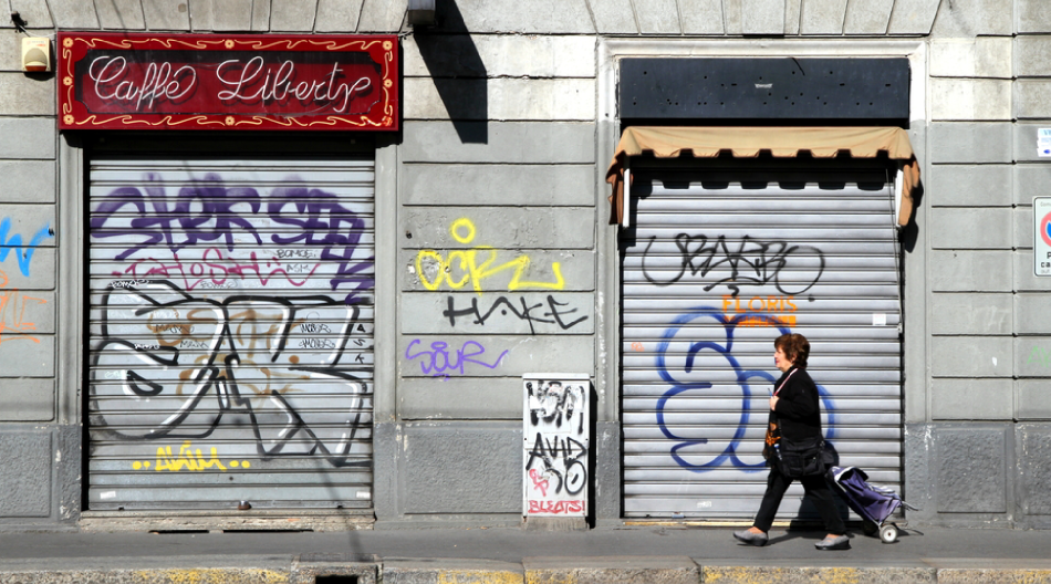 A middle-aged woman walking past closed business doors