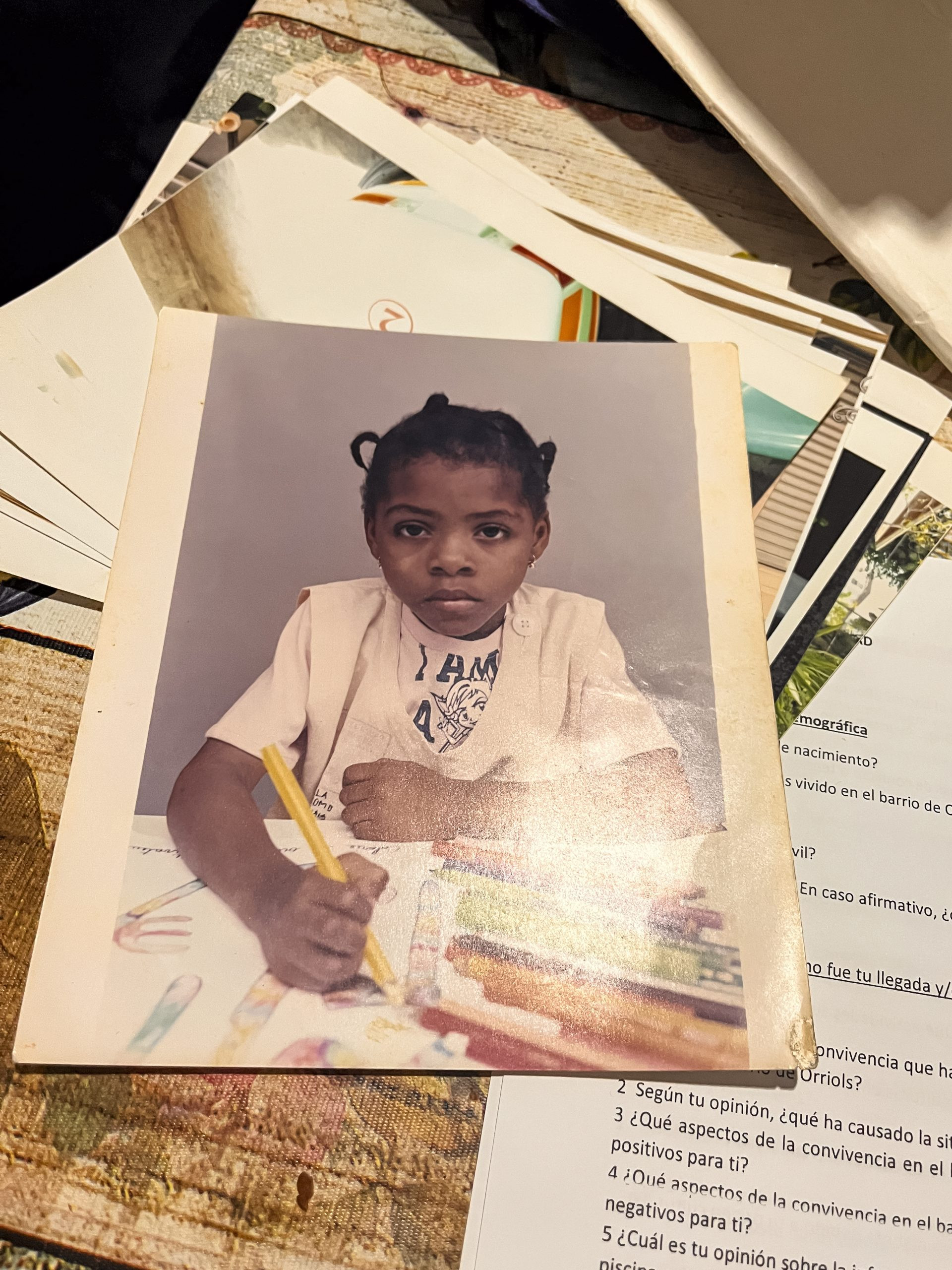 Classic kindergarten photo of a girl holding a marker, pretending to write.