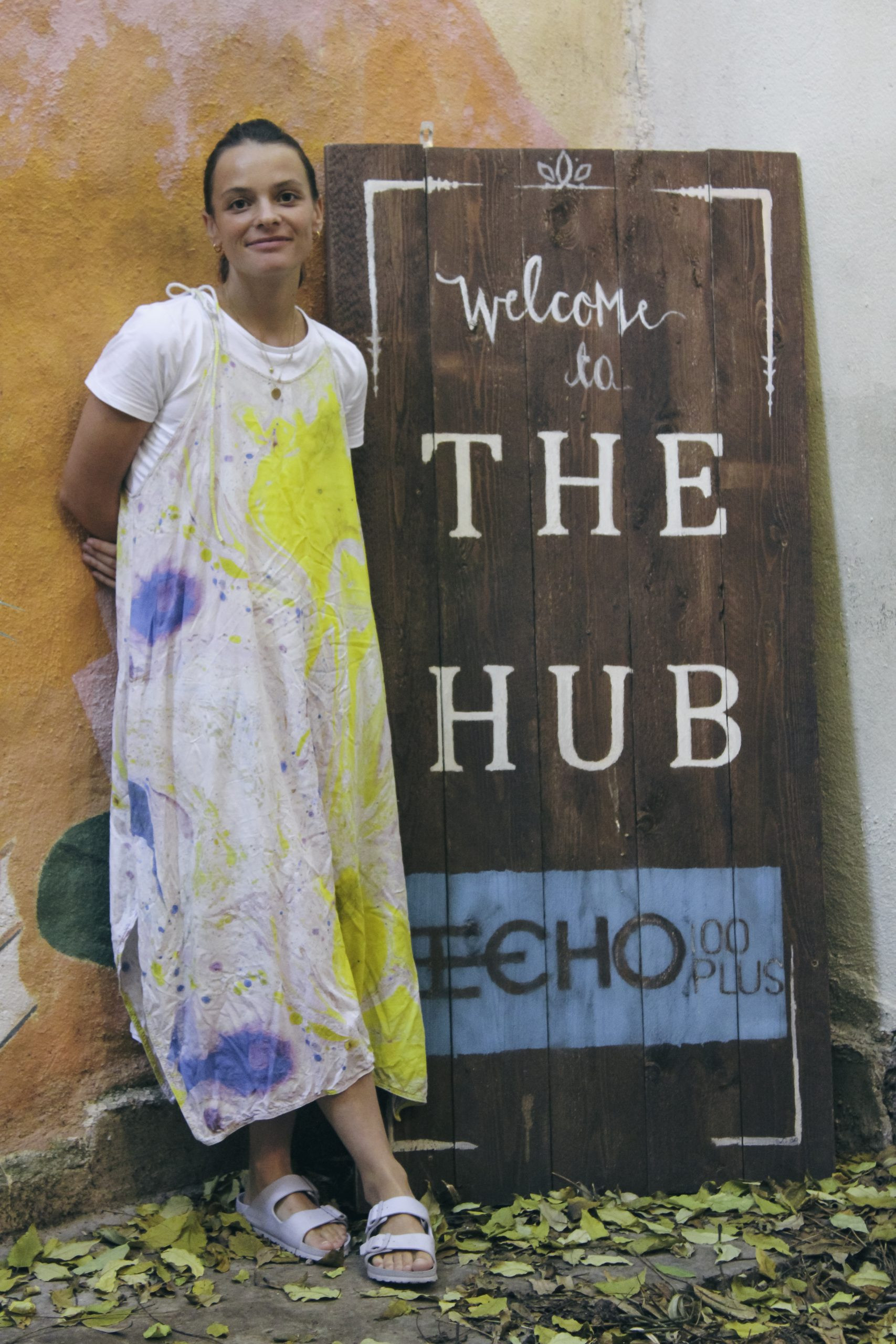 A woman standing next to a "Welcome to the hub" sign.